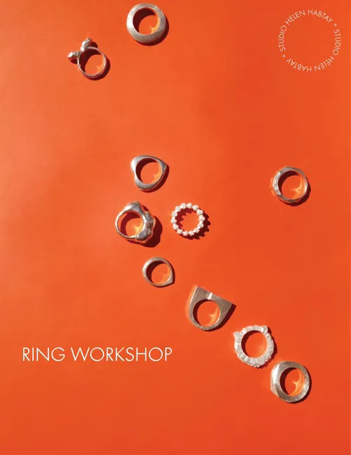 Verschiedene handgemachte Ringe auf orangefarbenem Hintergrund.