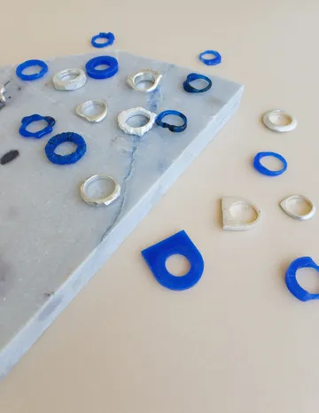Colourful rings are scattered on a grey background.