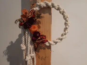 Decorative wreath made of rope and dried flowers on the wall.