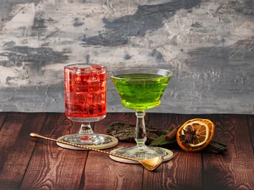Zwei Cocktails stehen auf einem hölzernen Tisch.