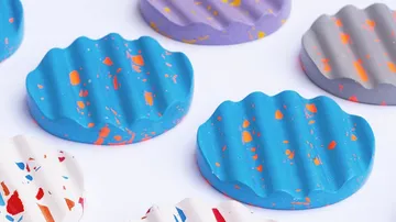 Colourful, wavy bars of soap lie on a white background.