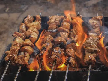 Skewers are grilled over open flames.