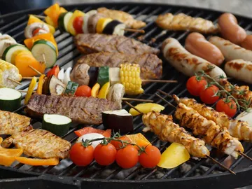 Gegrilltes Essen liegt auf einem Grill, vielfältige Sorten.