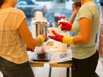 Two people prepare mixtures in a workshop.