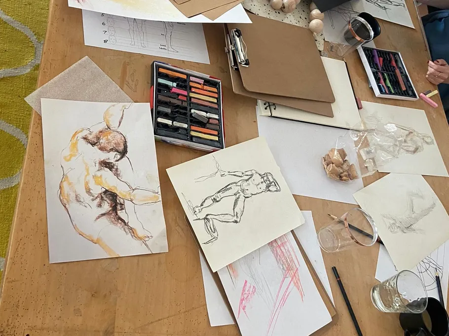 Drawings and materials are spread out on a table.