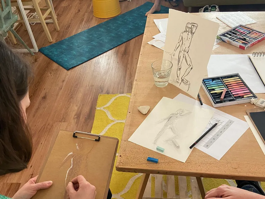 Eine Person zeichnet an einem Tisch in einem kreativen Raum.