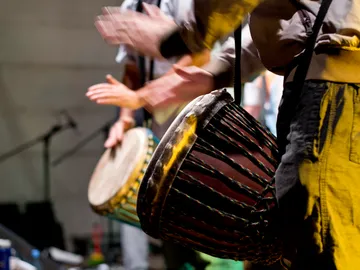Play drums, hit hands on instruments, on stage.