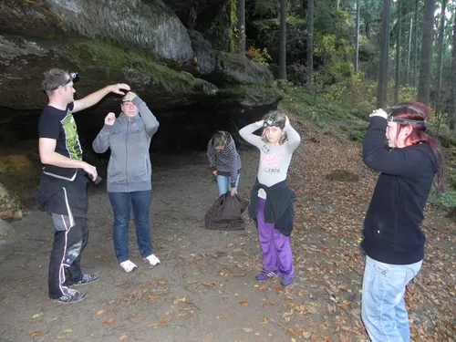 Gruppe von Menschen bereitet sich unter Felsen auf Aktivität vor.