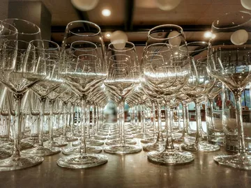 There are several glasses on a table in a bar.