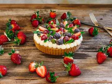 Cake with fresh berries on a wooden table.