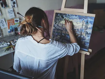 Artist is painting on a canvas in a quiet room.