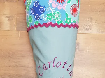 Colourful school bag with a name, placed on a wooden background.