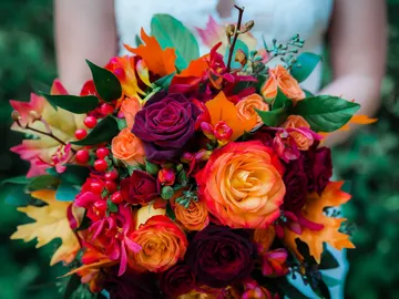 Strauß bunter Blumen wird von einer Person gehalten.
