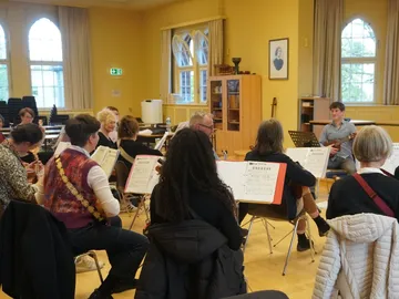 Musiker spielen in einem hellen Raum mit Noten.
