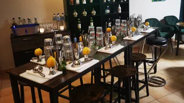 Bar mit Mixgeräten, Zitrusfrüchten und alkoholischen Getränken.