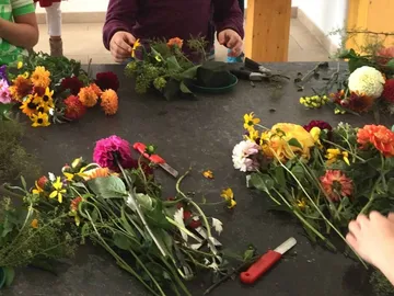 Bunte Blumenarrangements werden auf einem Tisch erstellt.