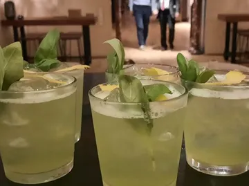 Green cocktails with ice and herbs in a bar.