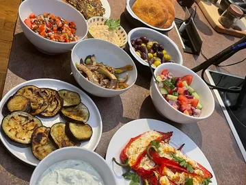 Essen in Schüsseln und Tellern auf einem Tisch arrangiert.