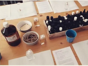 Flasche, Parfüm herstellen, auf einem Tisch mit Materialien.