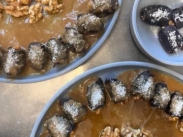 Two plates of sweet food and walnuts.