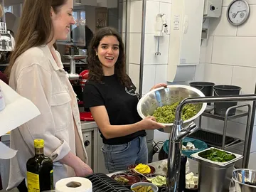 Zwei Frauen kochen zusammen in einer modernen Küche.