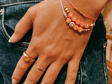 Händedruck trägt ein buntes, lustiges Armband aus Perlen.