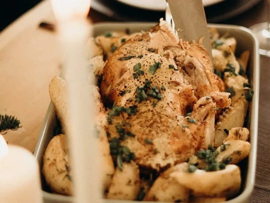 Roasted chicken is served on a table with side dishes.