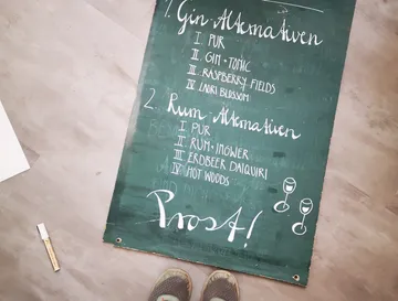 Board with drink cards for gin and rum, on wood.