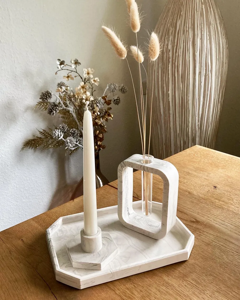 Kerzenhalter und Vase stehen auf einem Holztisch.
