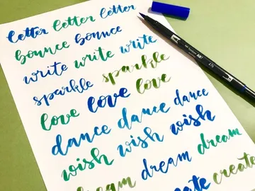 Colourful lettered paper with creative words and pens