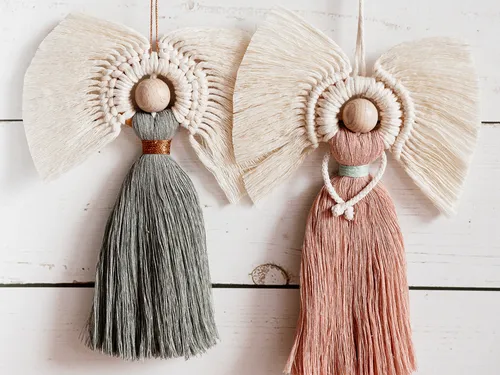 Two decorative angels hang on a wall.