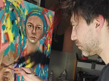 An artist paints a colorful portrait on canvas.