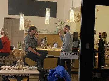 Two men are discussing at a bar counter in a bar.