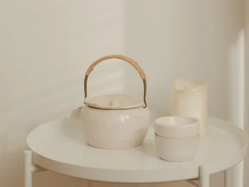 Kaffeekanne steht auf einem Tisch neben zwei Schalen.