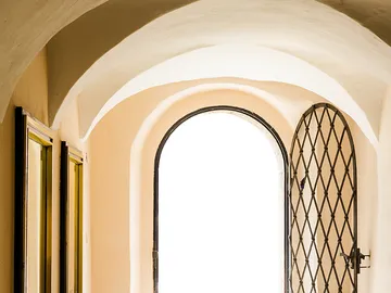 Door opens in a bright, arched passageway.