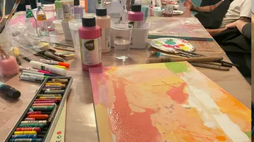 Paints, brushes and painting supplies on a work table.