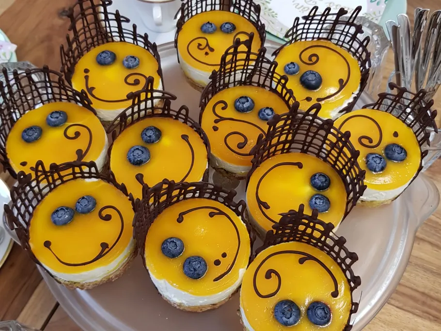 Mini-Käsekuchen mit Mangoglasur und Blaubeeren.