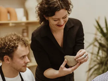 Woman shows sound object to an audience in a creative space.