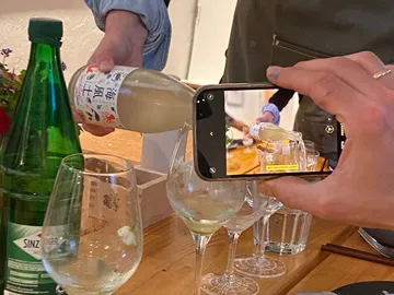 The bottle is poured; surrounded by glasses and a camera.