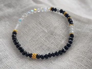 The piece of jewelry lies quietly on a textured fabric background.