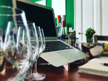 Glasses are placed on a table in front of a laptop.