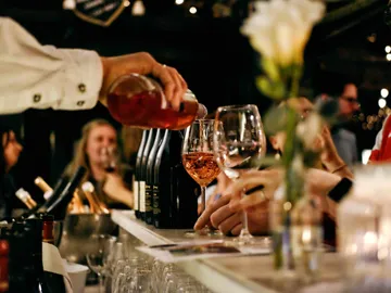 Gläser werden mit Wein an einer Bar gefüllt.