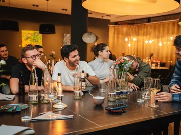 Menschen lachen und unterhalten sich in einem Restaurant.