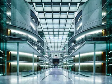 Modern building with glass walls, bright light, open spaces.