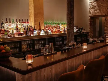 Elegant bar with shelves full of spirits and cozy lighting.