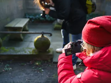 A person is taking pictures in a quiet garden area.