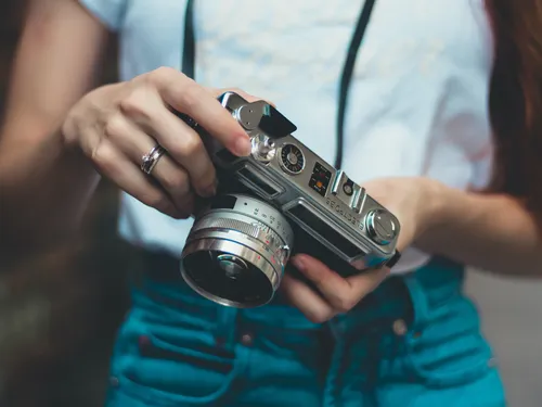 A camera in a person's hand is adjusted.