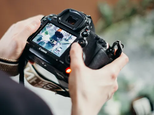 Eine Kamera wird zum Fotografieren von Objekten gehalten.