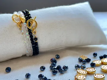 Armbänder liegen auf einem weißen Kissen, mit Glitzern.