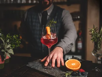 Eleganter Cocktail mit Eis wird auf einem Tisch serviert.